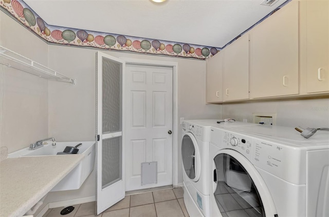 laundry room featuring cabinets, light tile patterned flooring, and washing machine and clothes dryer