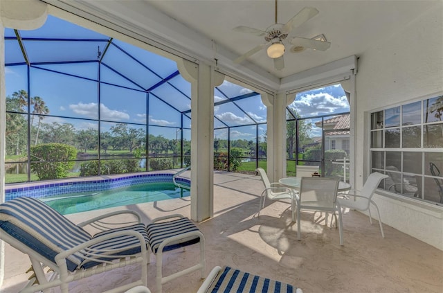 view of pool with a patio, glass enclosure, and ceiling fan