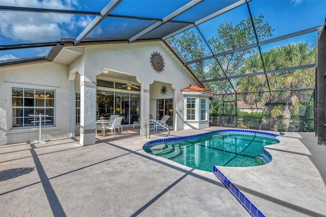 view of pool with glass enclosure, ceiling fan, and a patio