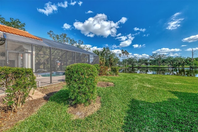 view of yard featuring glass enclosure and a water view