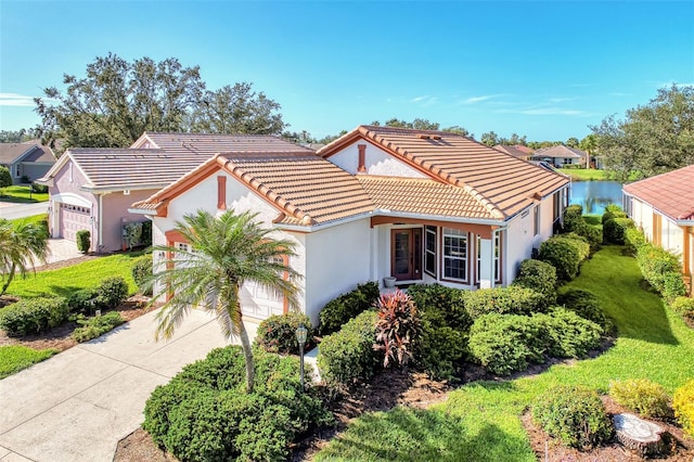 mediterranean / spanish-style home featuring a garage and a water view