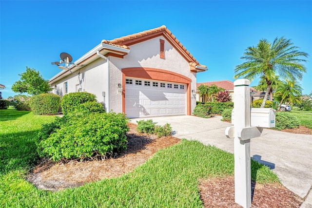 mediterranean / spanish-style home featuring a front yard and a garage