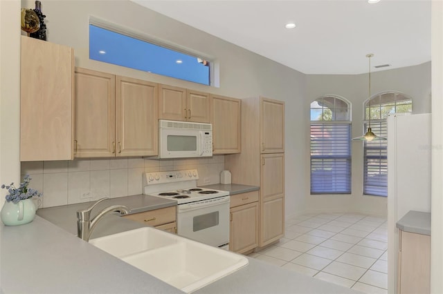 kitchen featuring sink, white appliances, hanging light fixtures, light tile patterned floors, and light brown cabinetry