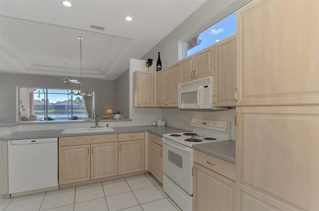 kitchen with a raised ceiling, sink, white appliances, a water view, and light brown cabinetry