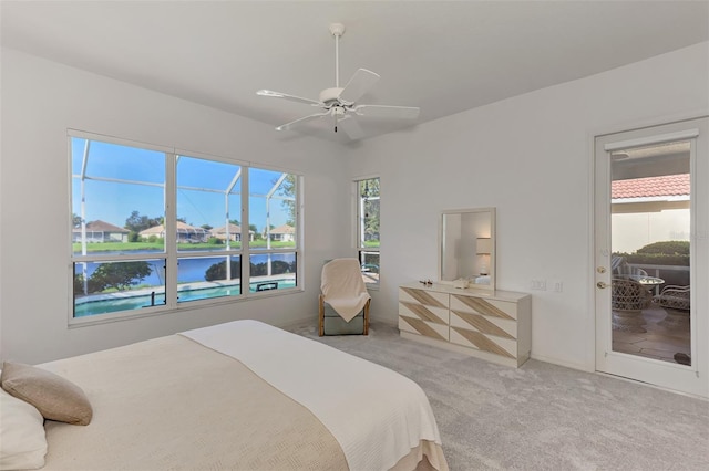 carpeted bedroom featuring ceiling fan, access to outside, and a water view