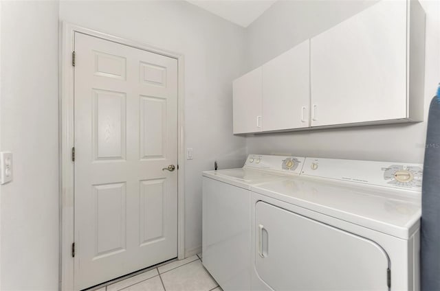 laundry area with cabinets, light tile patterned floors, and washing machine and clothes dryer