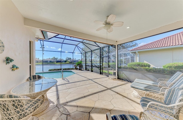 view of patio featuring a water view, ceiling fan, and a lanai