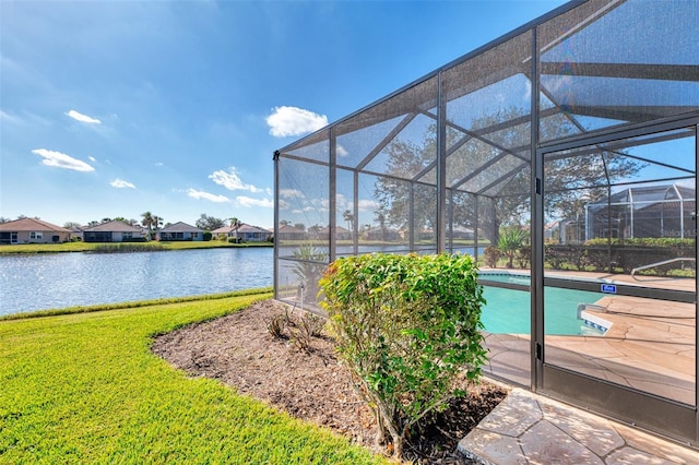 view of pool featuring glass enclosure, a water view, and a yard