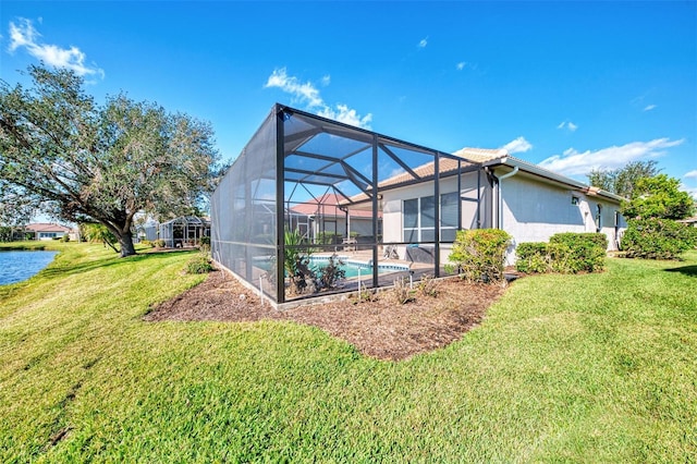 back of house featuring a lanai and a yard