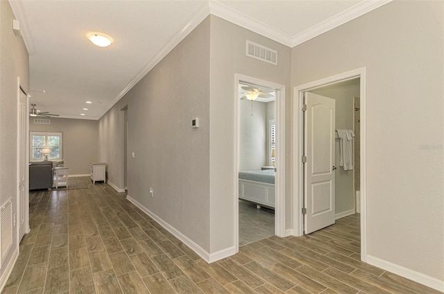 hall with hardwood / wood-style flooring and crown molding