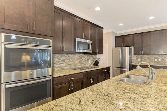 kitchen featuring tasteful backsplash, light stone counters, dark brown cabinets, stainless steel appliances, and sink