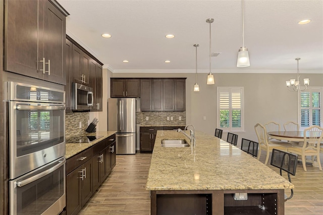 kitchen featuring a kitchen island with sink, plenty of natural light, hanging light fixtures, and appliances with stainless steel finishes