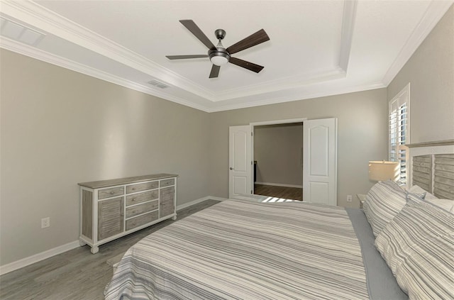 bedroom with a tray ceiling, ceiling fan, hardwood / wood-style floors, and ornamental molding