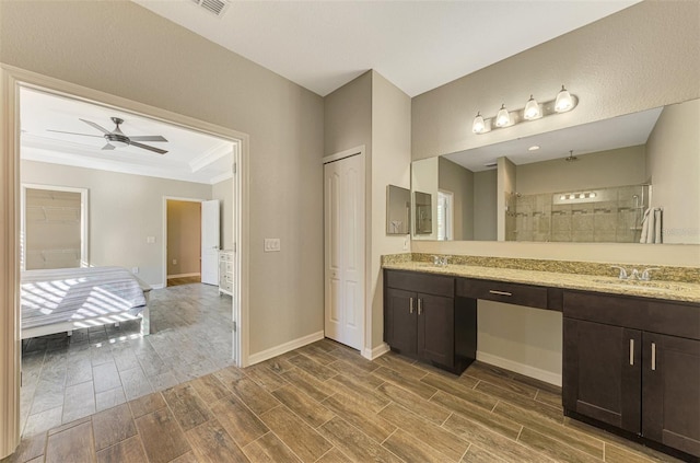 bathroom featuring ceiling fan, crown molding, walk in shower, and vanity