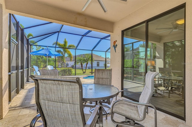 view of patio featuring glass enclosure and ceiling fan