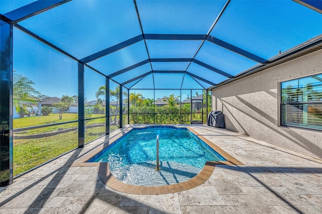 view of swimming pool featuring a lanai, a lawn, and a patio