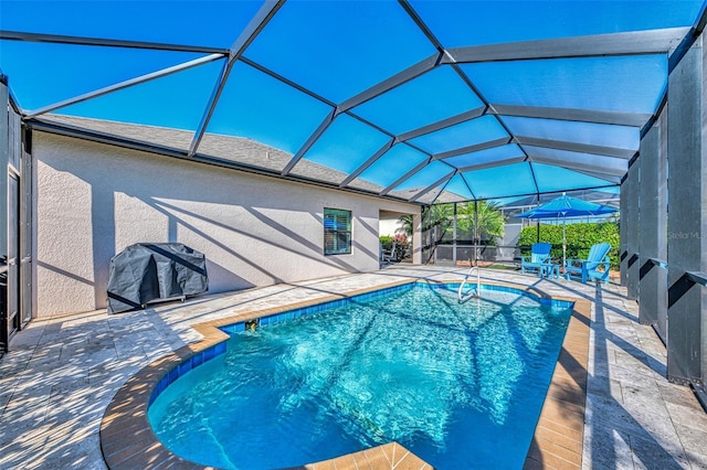 view of swimming pool with a patio, glass enclosure, and grilling area