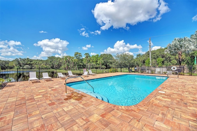 view of pool featuring a water view and a patio