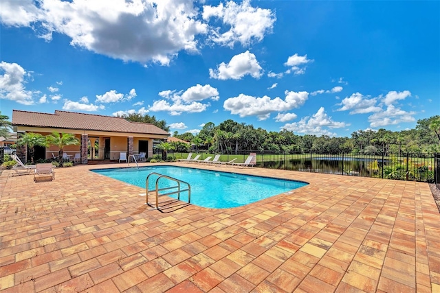 view of swimming pool with a water view and a patio