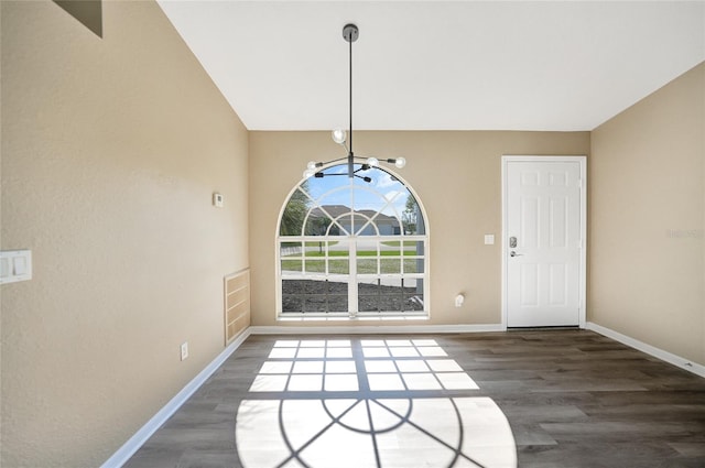 unfurnished dining area with vaulted ceiling, dark wood-type flooring, and a notable chandelier