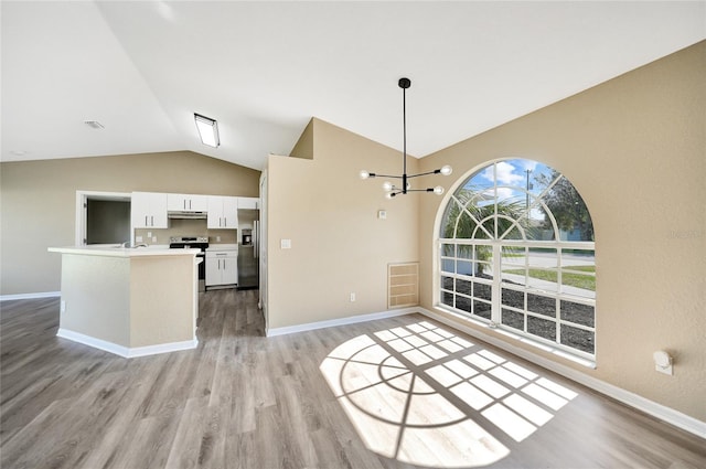 unfurnished dining area featuring light hardwood / wood-style floors, vaulted ceiling, and an inviting chandelier