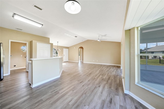 unfurnished living room featuring ceiling fan, lofted ceiling, and light wood-type flooring