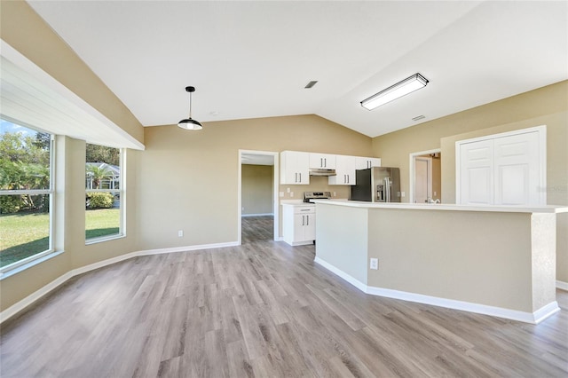 kitchen featuring a wealth of natural light, white cabinets, stainless steel appliances, and lofted ceiling