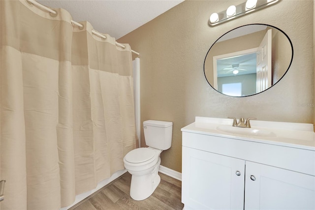 bathroom with ceiling fan, hardwood / wood-style floors, a textured ceiling, toilet, and vanity