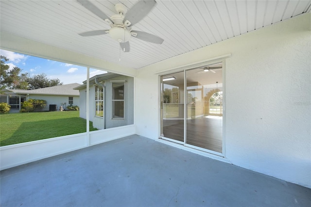 unfurnished sunroom featuring ceiling fan