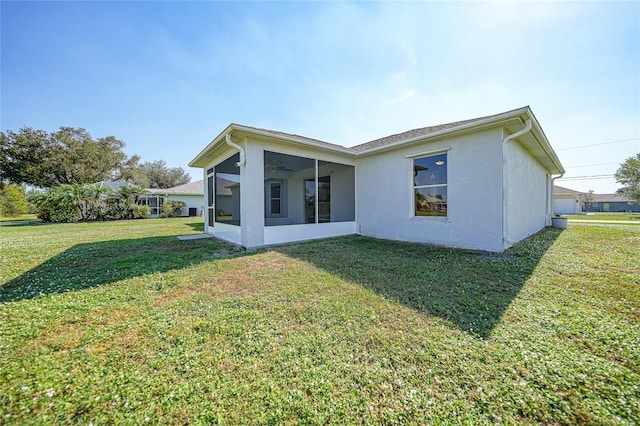 back of property featuring a lawn and a sunroom