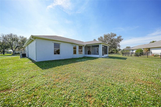 back of property with a yard, cooling unit, and a sunroom