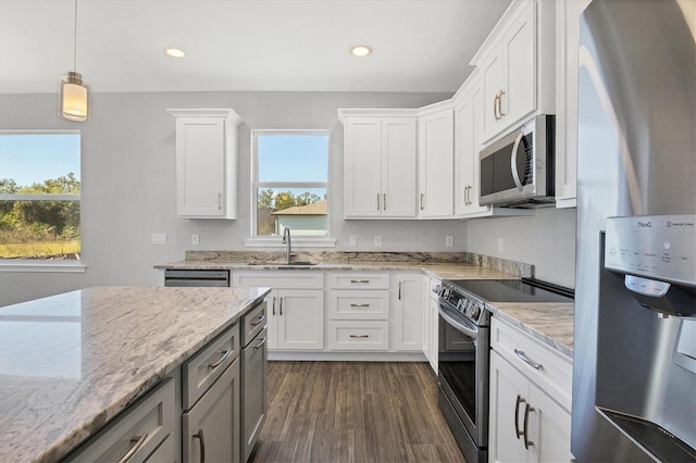 kitchen with a wealth of natural light, sink, white cabinets, and appliances with stainless steel finishes