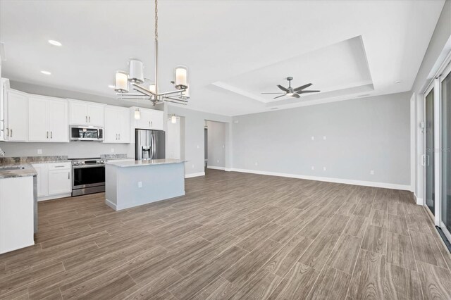 kitchen with white cabinets, a center island, appliances with stainless steel finishes, and light hardwood / wood-style flooring