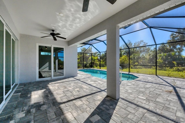 view of pool with glass enclosure, ceiling fan, and a patio