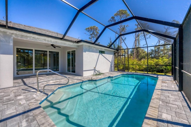 view of swimming pool featuring ceiling fan, a patio, and glass enclosure