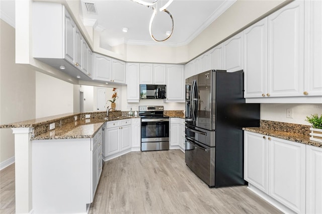 kitchen featuring kitchen peninsula, stainless steel appliances, white cabinets, and dark stone countertops