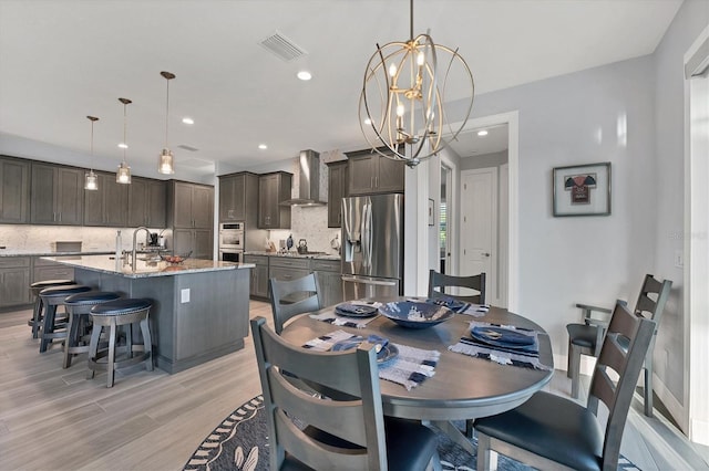 dining area featuring a chandelier, light hardwood / wood-style floors, and sink