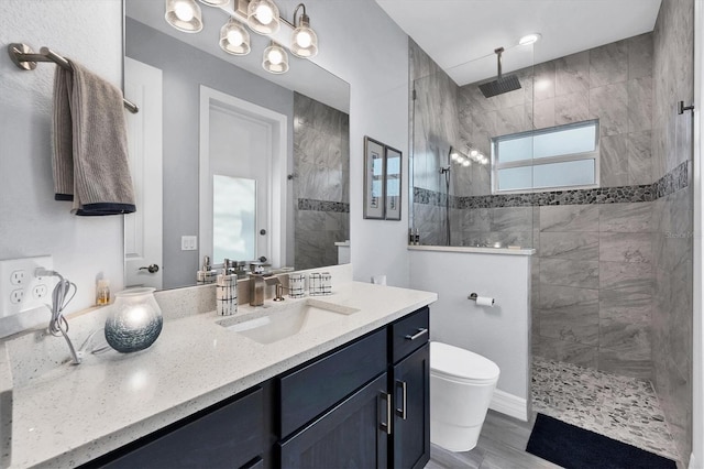 bathroom featuring tiled shower, toilet, vanity, and hardwood / wood-style flooring