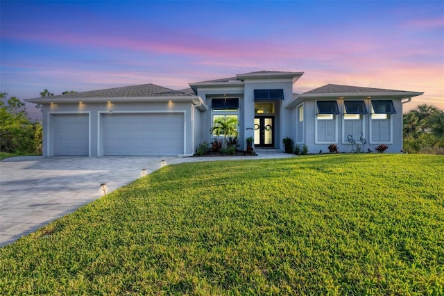 view of front of property featuring a lawn and a garage