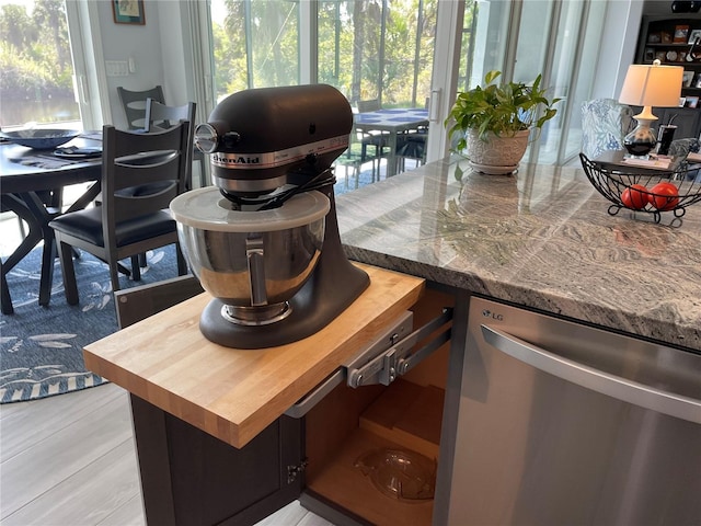 interior space featuring stainless steel dishwasher and light stone counters