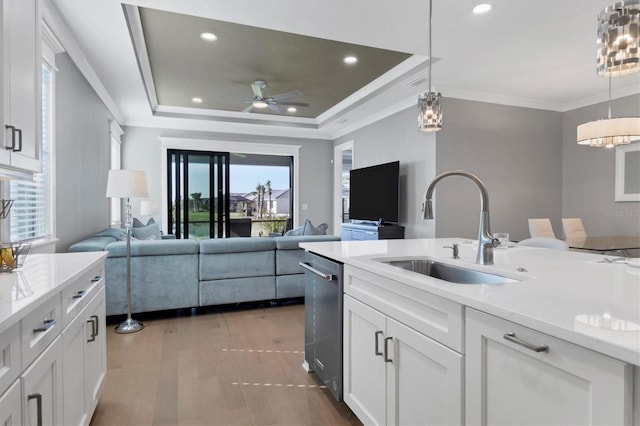 kitchen featuring white cabinets, a wealth of natural light, sink, and hanging light fixtures