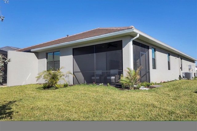 back of property with a sunroom, central AC unit, and a yard