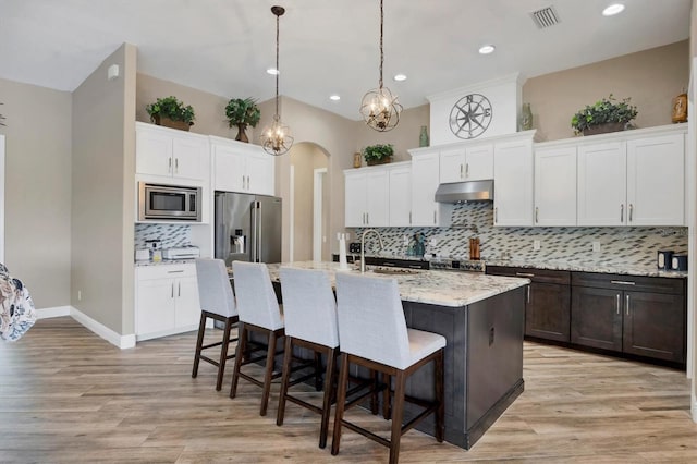 kitchen featuring stainless steel appliances, sink, pendant lighting, a center island with sink, and white cabinetry