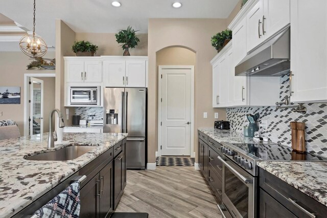 kitchen with sink, white cabinetry, stainless steel appliances, and light hardwood / wood-style flooring