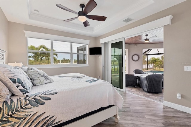 bedroom with access to exterior, ornamental molding, a raised ceiling, ceiling fan, and light hardwood / wood-style floors