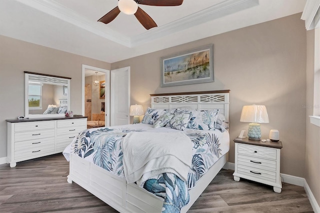 bedroom with ceiling fan, crown molding, dark wood-type flooring, and connected bathroom