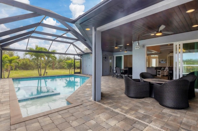 view of pool with ceiling fan, a patio, and glass enclosure