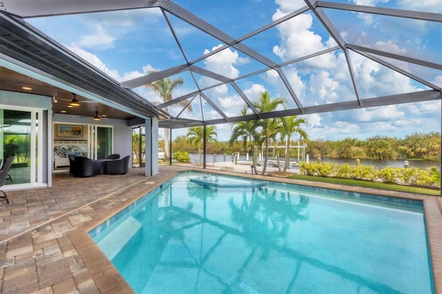 view of swimming pool with ceiling fan, a lanai, and a patio