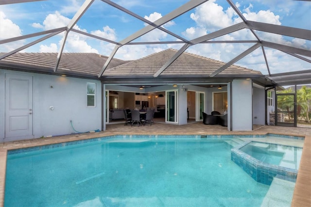 view of swimming pool featuring an in ground hot tub, a patio, and glass enclosure