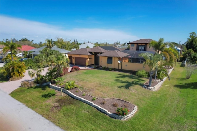 view of front of house with glass enclosure, a front lawn, and a garage